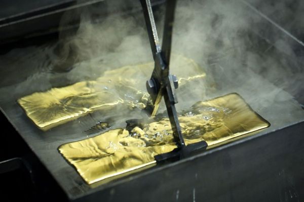 Gold bars being pulled from a water bath